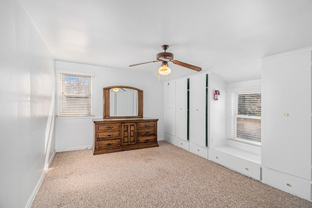 unfurnished bedroom featuring a closet, baseboards, ceiling fan, and carpet flooring