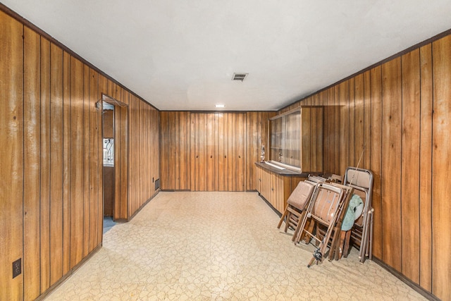 interior space with visible vents, light floors, and wooden walls