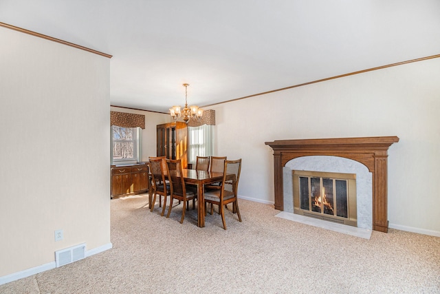 dining area with a high end fireplace, visible vents, a chandelier, and carpet floors