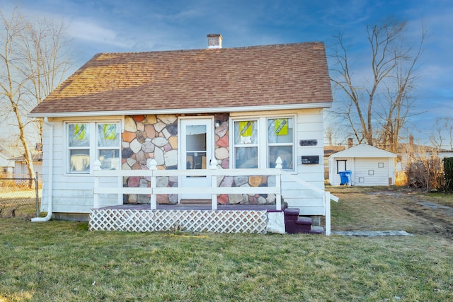 view of front of property featuring a front lawn, a chimney, and roof with shingles