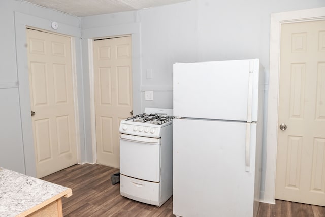 kitchen featuring white appliances, light countertops, and dark wood-type flooring