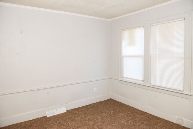 carpeted spare room featuring visible vents and ornamental molding