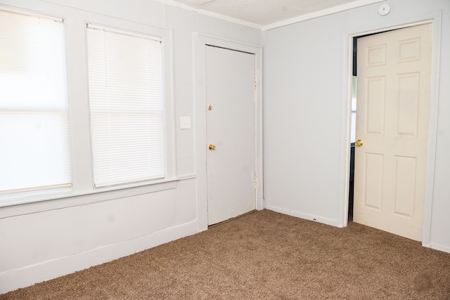 interior space with carpet flooring and crown molding