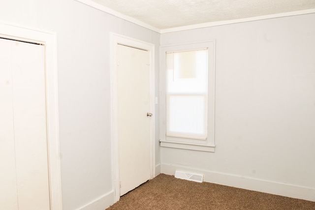 empty room featuring carpet, visible vents, and baseboards