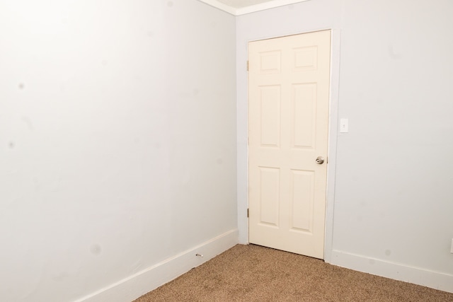 spare room with baseboards and light carpet