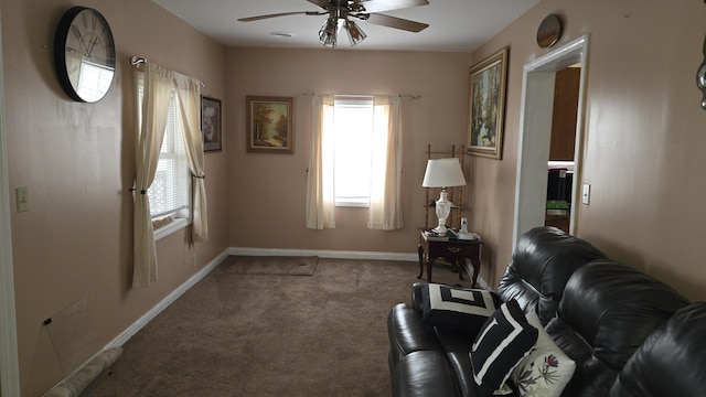 living area featuring carpet flooring, a ceiling fan, and baseboards