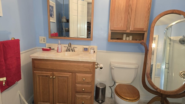 bathroom with vanity, a shower stall, and toilet