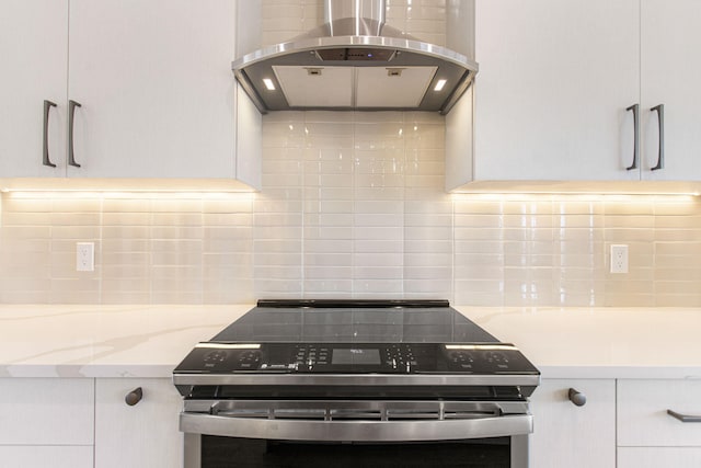 1 N Bailey Ave # 1, South Haven, MI 49090 - kitchen featuring extractor fan, electric stove, tasteful backsplash, and white cabinets