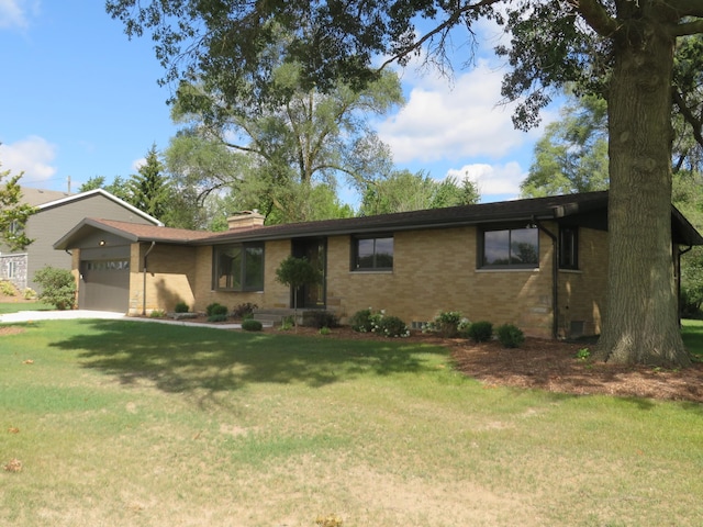 ranch-style home featuring a front lawn, an attached garage, brick siding, and a chimney