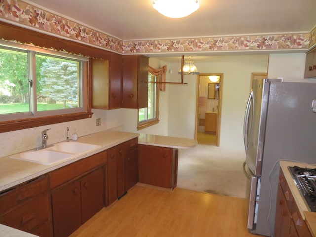 kitchen featuring a wealth of natural light, light countertops, freestanding refrigerator, and a sink