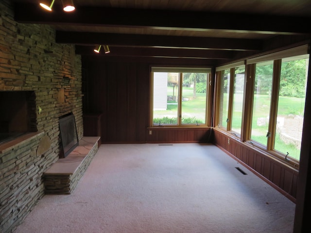 unfurnished sunroom with beam ceiling, a fireplace, and visible vents