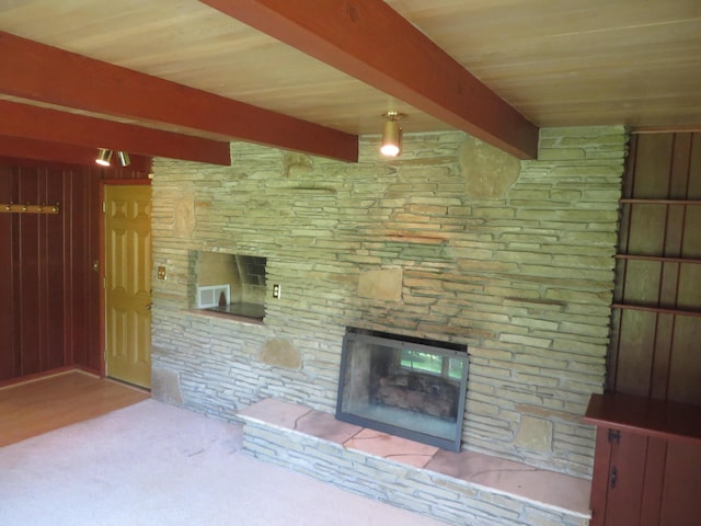 unfurnished living room with beam ceiling and a fireplace