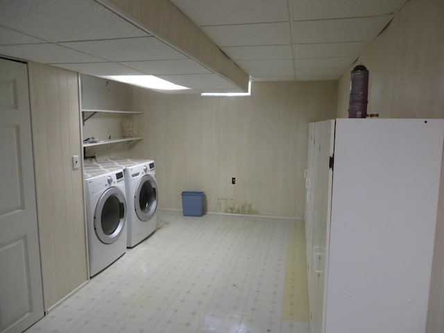 laundry area featuring tile patterned floors, laundry area, independent washer and dryer, and wooden walls