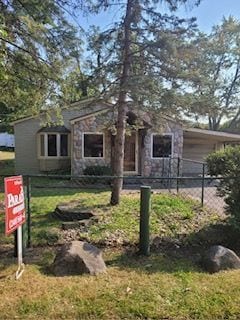 view of front of home with fence and stone siding