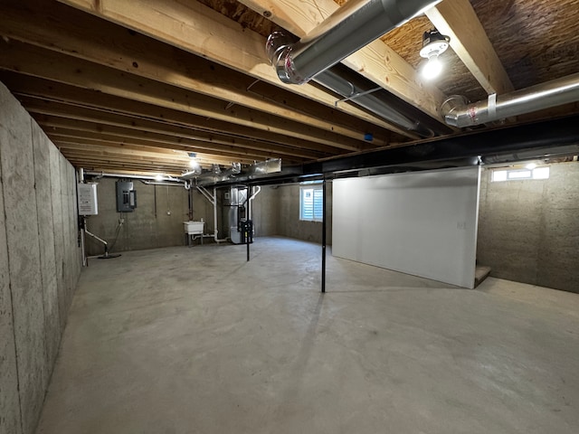 basement with electric panel, heating unit, and a sink