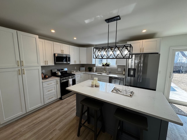 kitchen with decorative backsplash, a healthy amount of sunlight, stainless steel appliances, and light wood-style floors