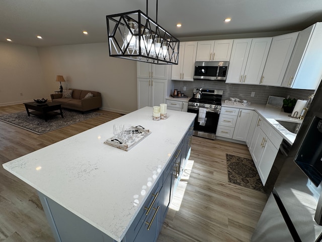 520 E Evelyn Ave, Hazel Park, MI 48030 - kitchen featuring white cabinetry, open floor plan, appliances with stainless steel finishes, and a center island