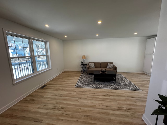 living room featuring light wood-style flooring, recessed lighting, visible vents, and baseboards