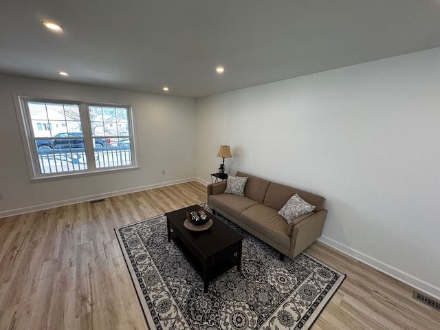 living room featuring recessed lighting, visible vents, baseboards, and light wood-style flooring