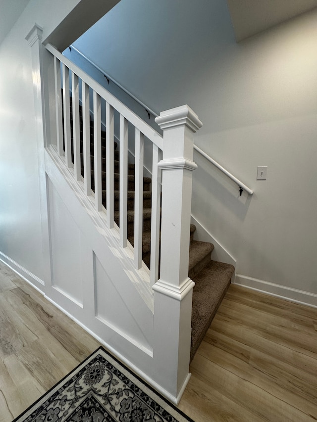 stairway featuring baseboards and wood finished floors