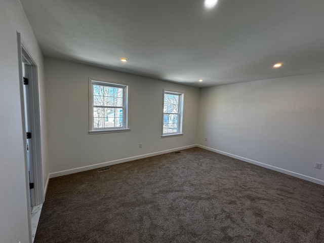 spare room with recessed lighting, baseboards, visible vents, and dark carpet