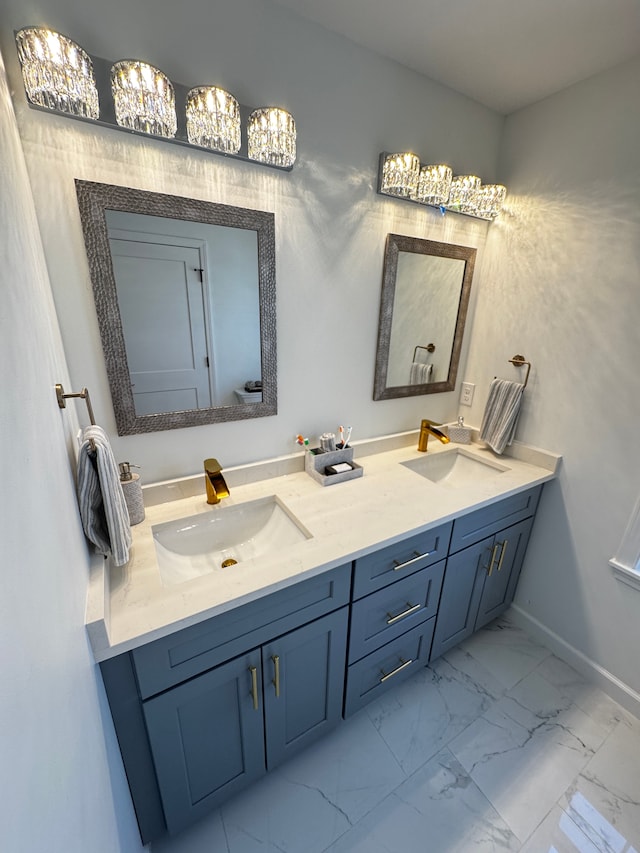 bathroom with double vanity, marble finish floor, and a sink