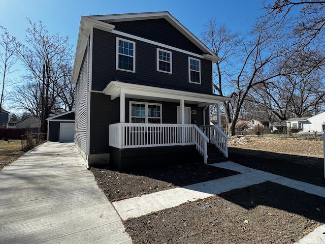 view of front of property with a porch, a detached garage, and an outdoor structure