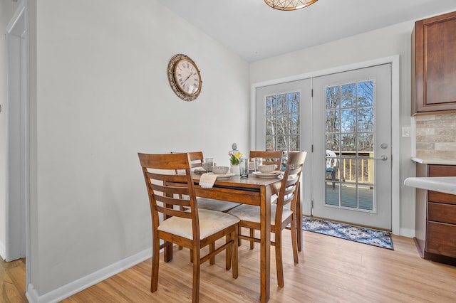 dining room with baseboards and light wood-type flooring