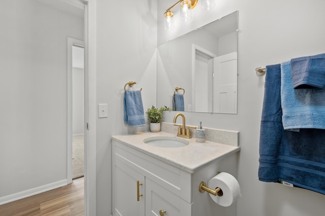 bathroom with vanity, wood finished floors, and baseboards