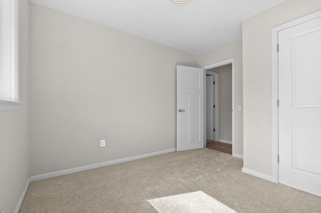 unfurnished bedroom with baseboards and carpet flooring