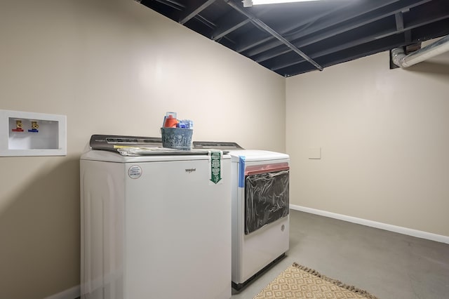 clothes washing area with baseboards, washing machine and dryer, and laundry area