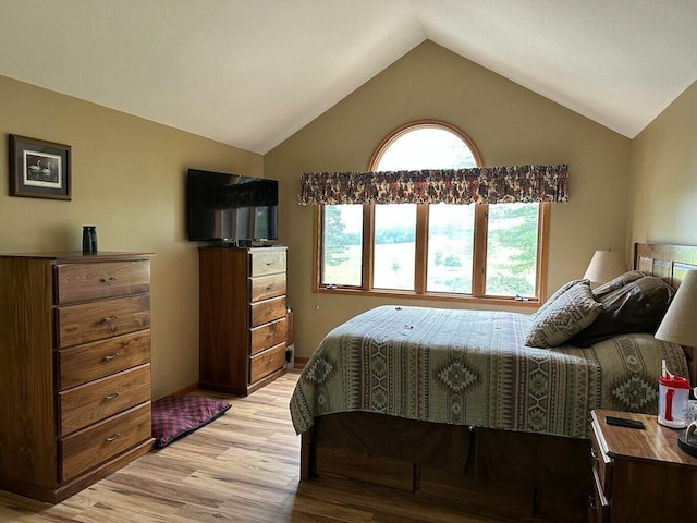 bedroom with baseboards, light wood-style floors, and lofted ceiling