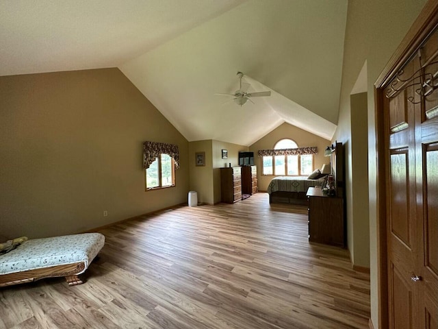 unfurnished bedroom featuring light wood-style flooring, multiple windows, baseboards, and high vaulted ceiling