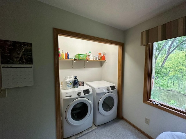 clothes washing area with baseboards, laundry area, and washing machine and clothes dryer