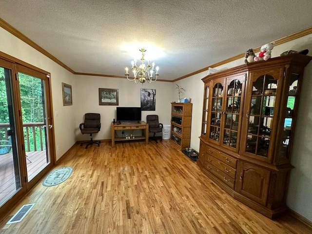 unfurnished office with light wood-type flooring, visible vents, a notable chandelier, and ornamental molding