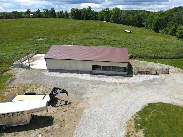 entry to storm shelter featuring an outbuilding, a rural view, and a lawn