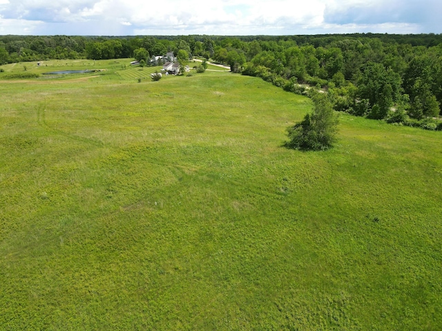 drone / aerial view featuring a rural view and a view of trees