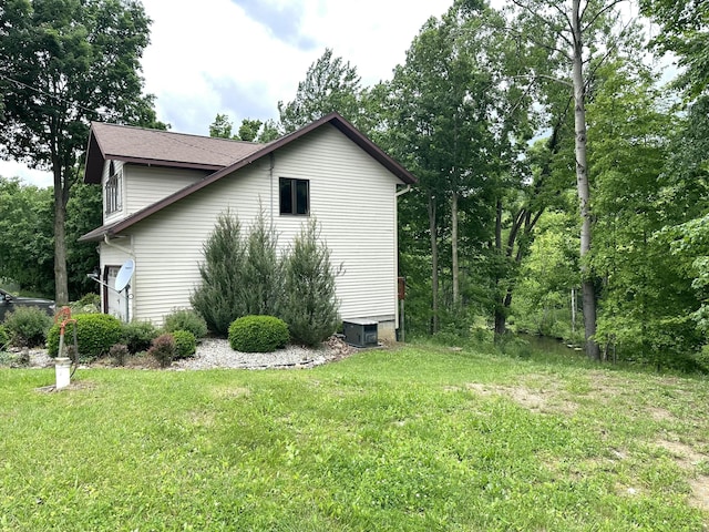 view of home's exterior featuring central AC unit and a yard