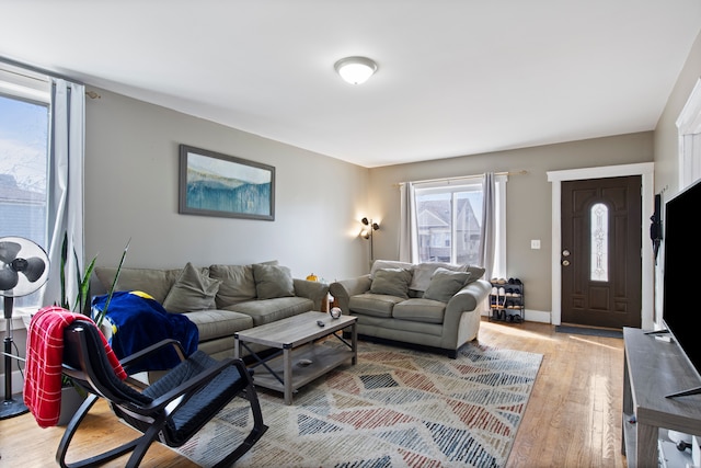 living area featuring baseboards and light wood-style floors