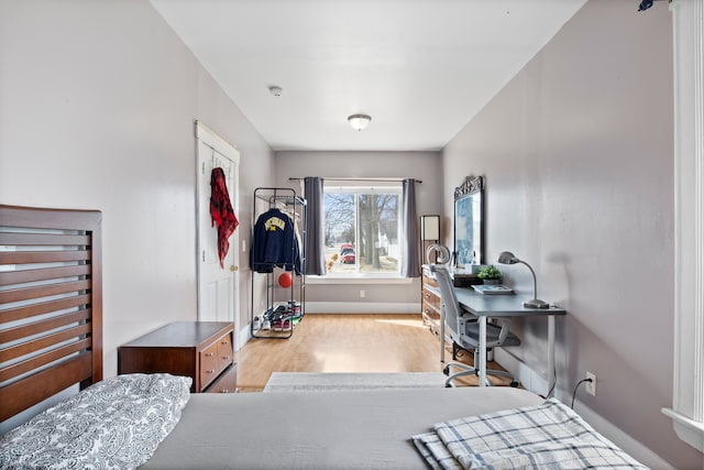 bedroom with baseboards and wood finished floors