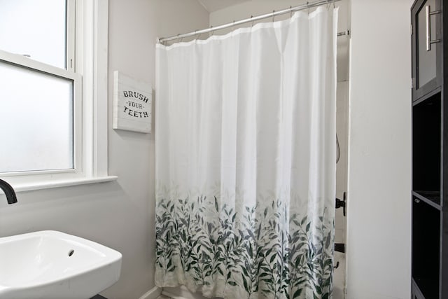 bathroom with a shower with shower curtain and a sink