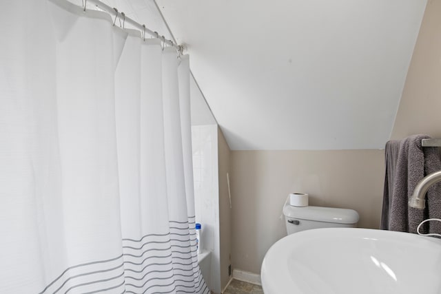 full bathroom featuring a sink, baseboards, toilet, and vaulted ceiling