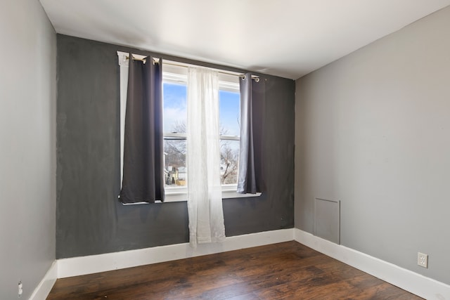 empty room featuring baseboards and wood finished floors