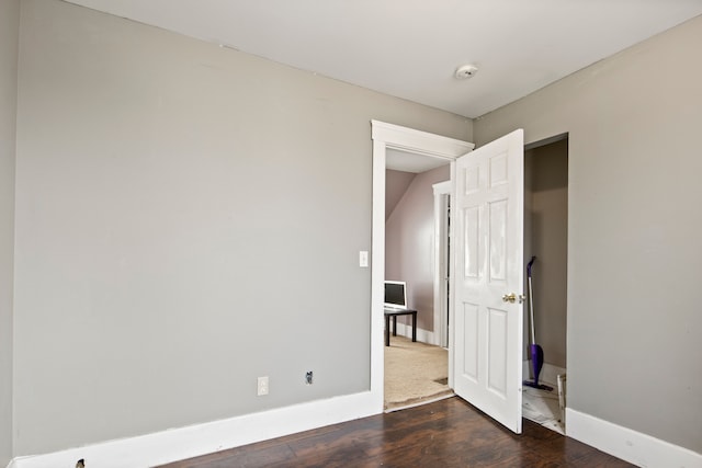 spare room with wood finished floors and baseboards