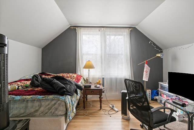 bedroom with lofted ceiling and wood finished floors