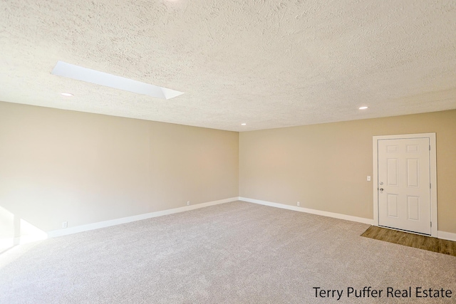 carpeted spare room featuring recessed lighting, baseboards, and a textured ceiling