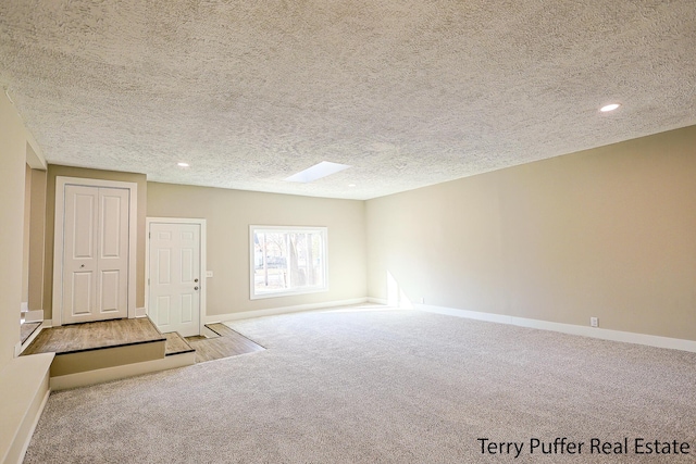 carpeted spare room featuring recessed lighting, baseboards, and a textured ceiling