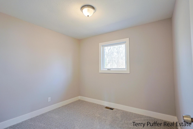 empty room with visible vents, baseboards, and carpet floors