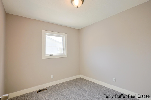 empty room with visible vents, baseboards, and carpet floors