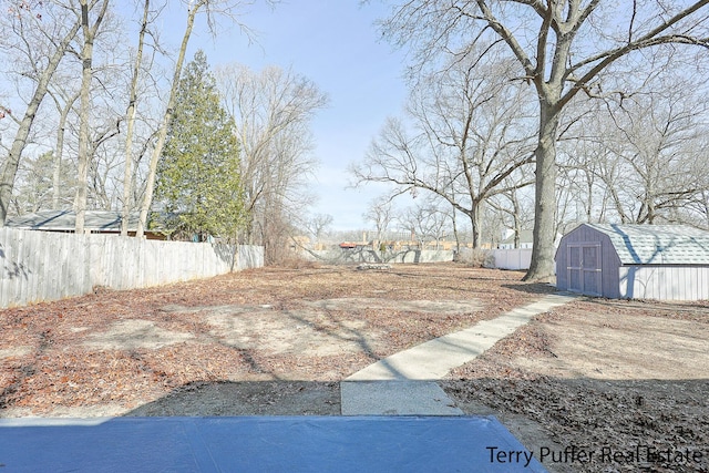 view of yard featuring a storage shed, an outdoor structure, and fence